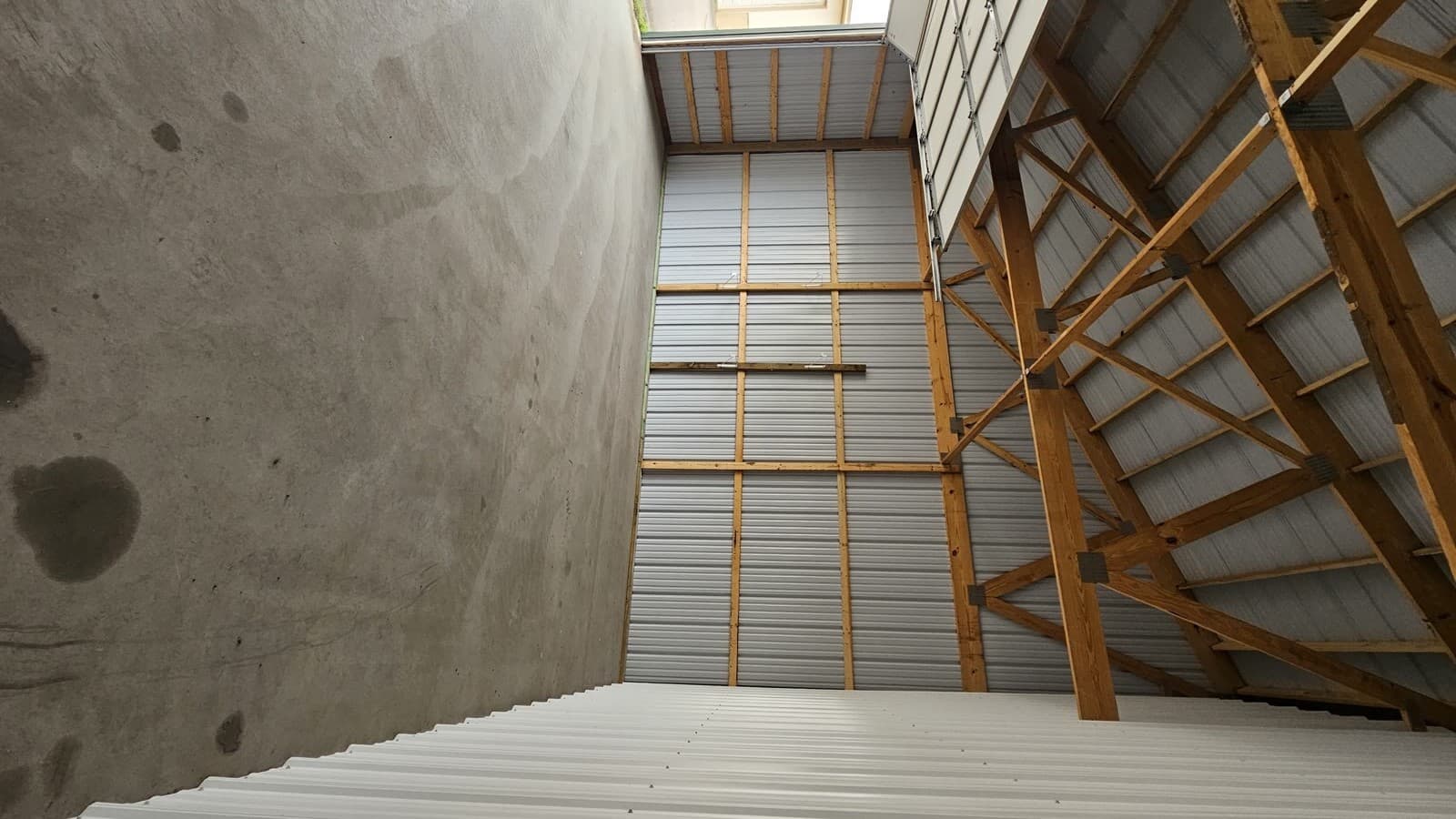 Inside view of storage unit with walk-in door and garage door open